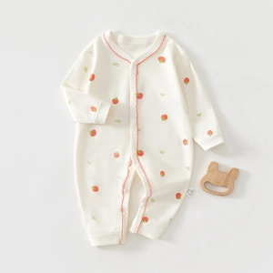 Détail du barboteuse bébé en coton avec bordure rouge ondulée et fraises