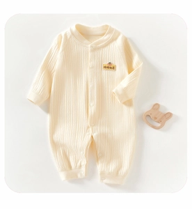 Détail d'un barboteuse bébé en maille côtelée avec broderie de kaki et boutons pression