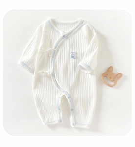 Detail of white cotton baby romper with blue trim and cute rabbit embroidery decoration