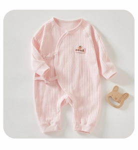 Detail of baby cotton jumpsuit with persimmon embroidery and soft ribbed fabric texture