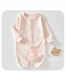 Détail d'une barboteuse rose à côtes pour bébé avec broderie lapin et texture douce