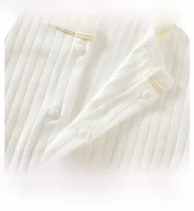 Detail view of white knitted baby bodysuit with four smooth functional snap fasteners