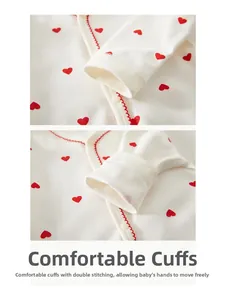 Détail du body bébé en coton avec motif cœur rouge et coutures ondulées