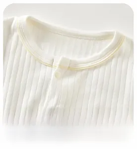 Close-up of baby ribbed cotton bodysuit with soft neckline and contrast piping detail