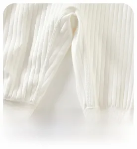 Detail of baby knitted romper showing the wide crotch and ribbed texture of white fabric