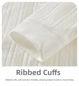 Detail view of soft ribbed cuffs on white cotton newborn bodysuit with hollow knit pattern