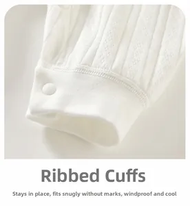 Détail du poignet en coton côtelé blanc avec bouton-pression pour body de bébé