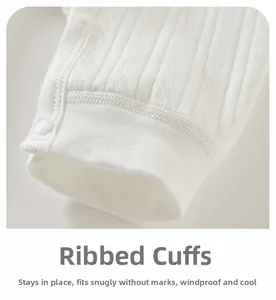 Detail of ribbed elastic cuffs and resin snap buttons on newborn cotton bodysuit
