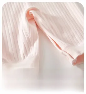 Détail de l'entrejambe élargi avec boutons-pression sur la barboteuse en coton doux
