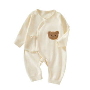 Newborn cotton romper with bear patch and side-tie closure in cream white color