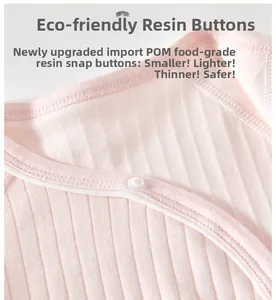 Detail of eco-friendly resin buttons on pink ribbed cotton newborn bodysuit