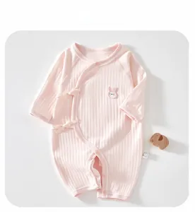 Detailed view of pink ribbed cotton baby romper with ribbon ties and rabbit embroidery