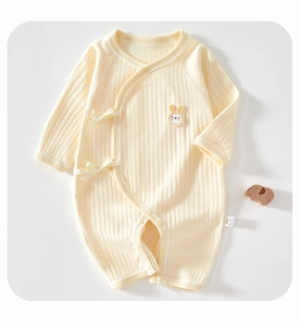 Detail of light yellow ribbed cotton baby romper with cute rabbit patch and side ties