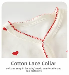 Détail d'un barboteuse bébé avec motif cœur et col en dentelle de coton doux