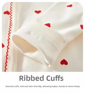 Détail des poignets côtelés avec motif de cœur rouge et couture ondulée sur barboteuse bébé