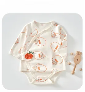 Détail d'un body bébé en coton à manches longues avec motifs citrouille et pressions