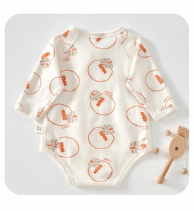 Vue détaillée du body bébé en coton avec imprimé Lotus et hochet ours en bois