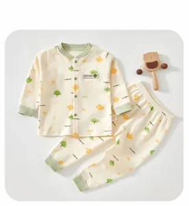 Flat lay of baby cotton loungewear set with tree patterns and wooden bear rattle