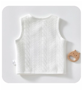 Dettaglio del gilet bianco in maglia per neonati con trama in cotone trapuntato