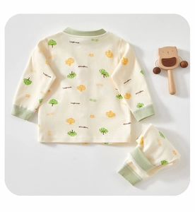 Detail of baby cotton pajama set with green tree prints and happiness text design