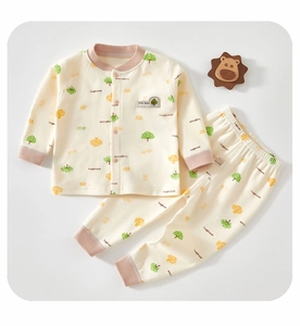 Detail of baby cotton pajama set with tree patterns and wood lion decor
