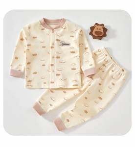Close-up of baby organic cotton pajama set with beige pattern and pink ribbed cuffs