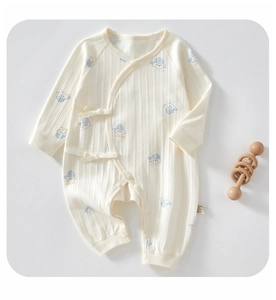 Detailansicht von Baby-Strampler aus Rippstrick mit blauen Hunden und Bindeband
