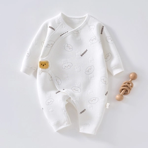Close-up of baby romper featuring delicate puppy prints and a yellow 3D bear patch detail