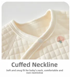 Detail of soft quilted cotton newborn top featuring a piped neckline and snap buttons