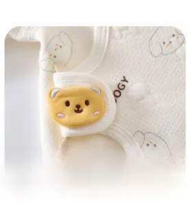 Close-up of baby romper showing breathable fabric and yellow bear adjustable velcro strap