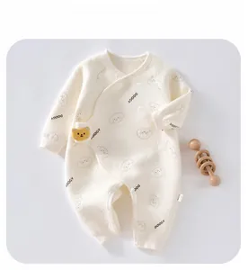 Detail of waffle knit baby romper with a cute bear plush and graphic prints