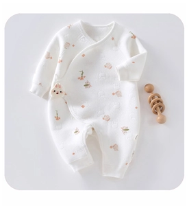 Detailed macro shot of waffle texture baby romper with rabbit floral pattern and plush bunny charm