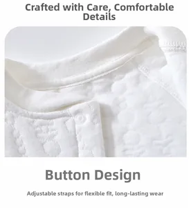 Close-up of baby romper collar with snap button and white textured cotton fabric