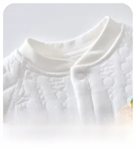 Close-up of baby romper ribbed neckline and soft cotton quilted fabric with embroidery