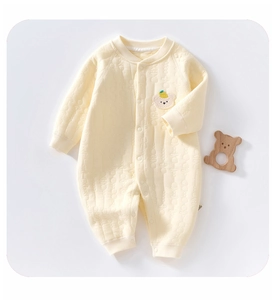 Detail of baby quilted romper featuring textured jacquard fabric and bear embroidery