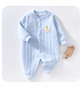 Detail of light blue quilted baby romper with soft fabric texture and bear embroidery