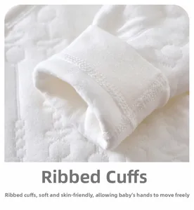 Détail des poignets côtelés et du coton gaufré sur un body blanc pour nouveau-né