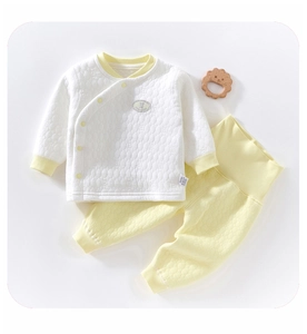 Detail of baby thermal quilted set showing ribbed cuffs and wooden lion toy decor