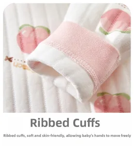 Détail des poignets roses élastiques et imprimé pêche sur la grenouillère matelassée