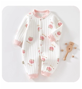 Détail d'une grenouillère matelassée pour bébé avec imprimés pêches et boutons-pression