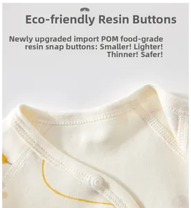 Détail d'un bouton-pression en résine POM écologique sur un vêtement bébé en coton