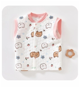 Detailed macro view of quilted baby vest featuring cartoon bear prints and pink piping