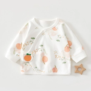 Detailed view of baby white cotton wrap top with peach print and orange fruit embroidery
