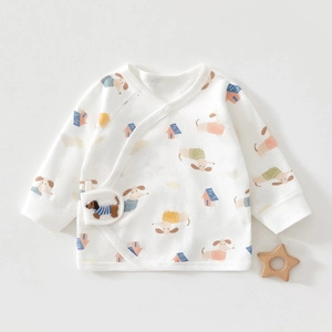 Detailed view of white cotton newborn wrap shirt with dog prints and plush patch