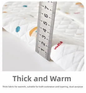 Macro detail of thick quilted baby vest fabric measured with ruler showing warm padding