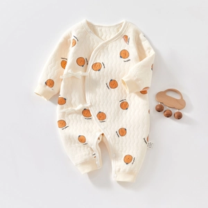 Close-up of quilted thermal baby jumpsuit with orange persimmon print and snap buttons
