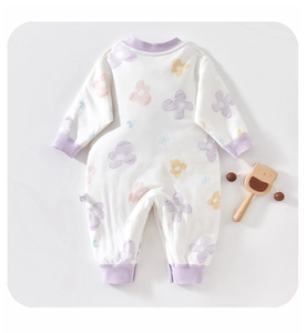 Detailed view of floral cotton baby romper with purple ribbed trims and a wooden bear toy