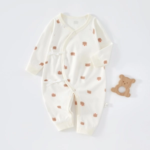 Detail of newborn cotton romper featuring a cute brown bear pattern and side-tie closure