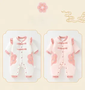 Detail of baby onesie with traditional frog buttons and delicate flower embroidery