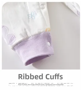 Detail of ribbed cuffs on baby floral cotton romper with secure snap buttons and soft fabric